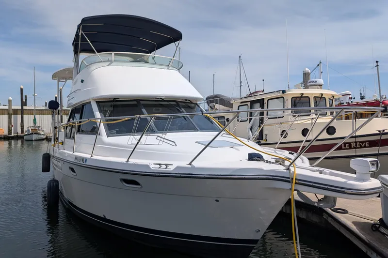 Slide: The Image of 2000 Bayliner 4088 yacht docked at marina, featuring sleek design and spacious deck. - 2