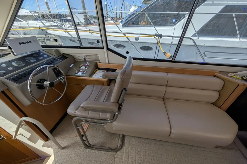 Slide: The Image of Interior of 2000 Bayliner 4088 yacht with steering wheel and beige seating. - 30