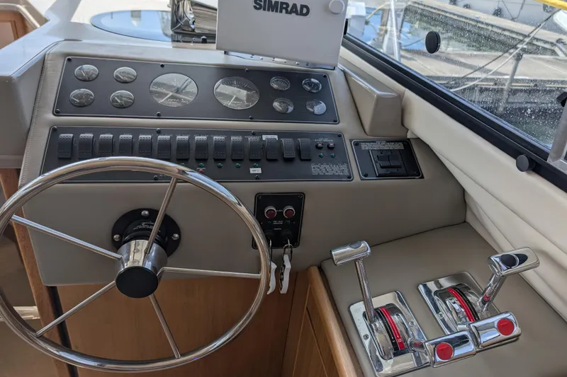 Slide: The Image of Control panel of a 2000 Bayliner 4088 boat with steering wheel and throttle levers. - 31