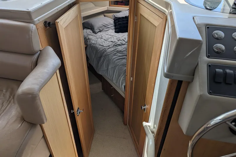Slide: The Image of Interior of 2000 Bayliner 4088 yacht showing cabin with bed and wooden doors. - 33