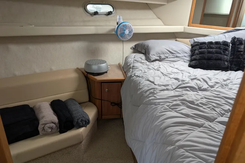 Slide: The Image of Cozy bedroom in 2000 Bayliner 4088 yacht with bed, fan, and folded towels. - 37