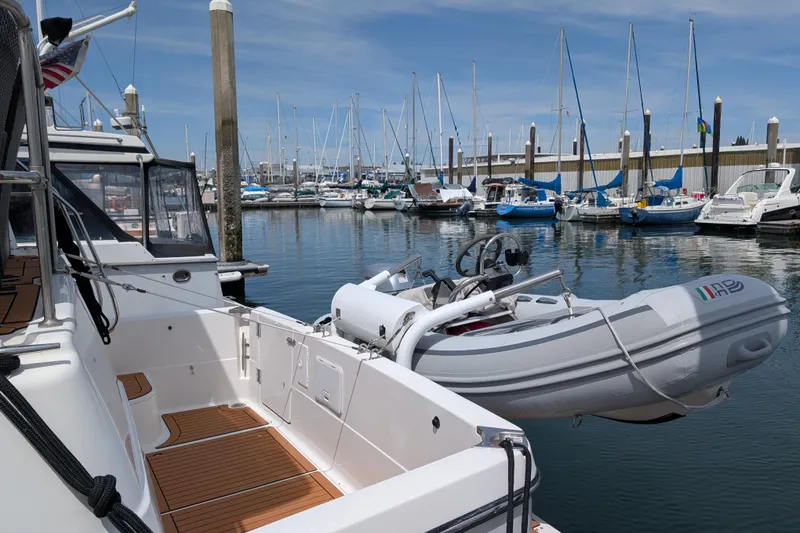 Slide: The Image of Bayliner 4088 yacht from 2000 docked with inflatable boat, surrounded by sailboats in marina. - 4