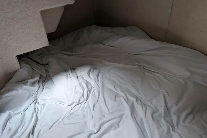 Slide: The Image of Interior cabin bed of a 2000 Bayliner 4088 boat with rumpled bedding. - 44