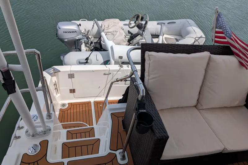 Slide: The Image of Bayliner 4088 yacht deck with seating, wooden flooring, and attached dinghy, 2000 model. - 8