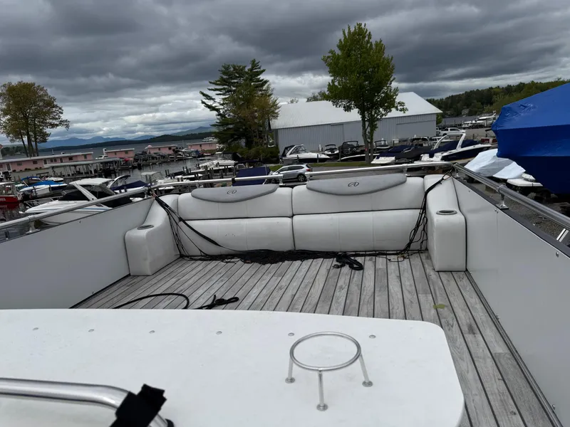 Slide: The Image of 2015 Avalon Paradise Funship 27' pontoon boat with spacious deck and seating, docked under cloudy skies. - 11