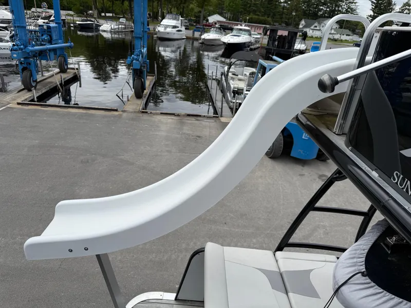 Slide: The Image of 2015 Avalon Paradise Funship with slide at marina, surrounded by boats. - 12