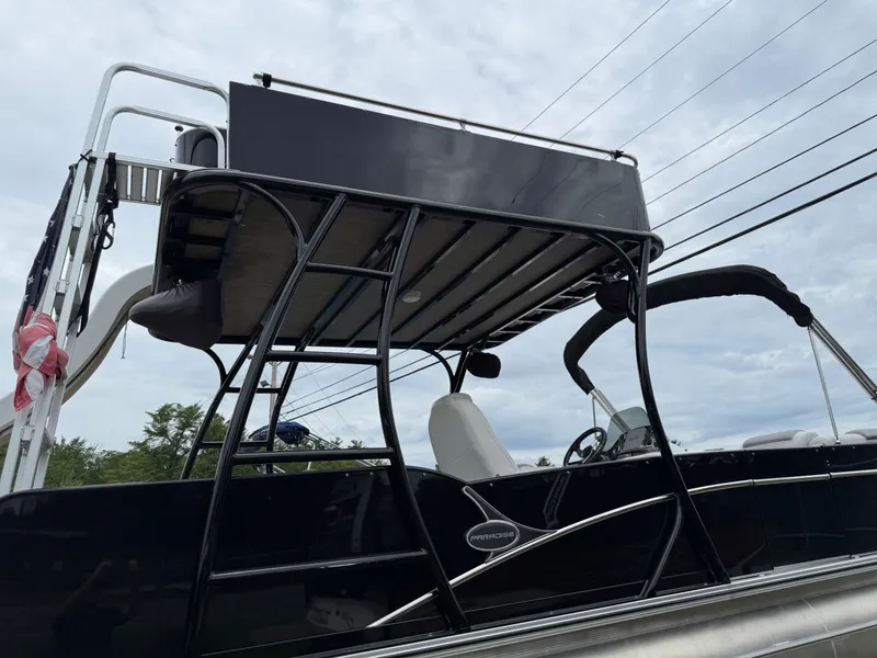 Slide: The Image of 2015 Avalon Paradise Funship pontoon boat with upper deck and slide, under cloudy sky. - 18