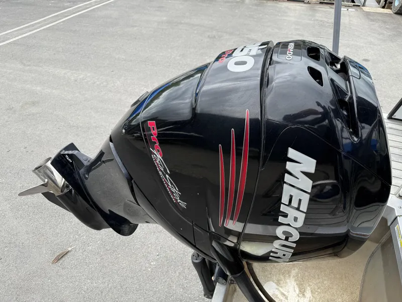 Slide: The Image of Mercury outboard motor on 2015 Avalon Paradise Funship 27' boat, parked on pavement. - 9