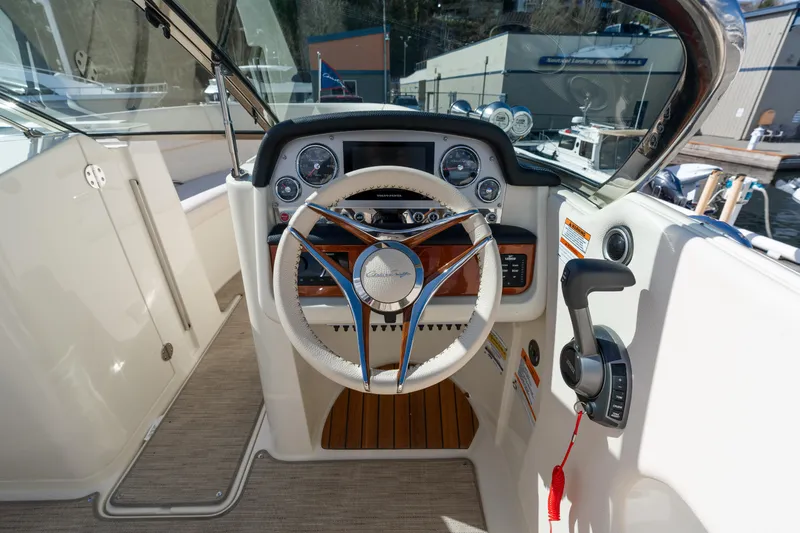 Slide: The Image of 2022 Chris-Craft Launch 27 boat cockpit with steering wheel and control panel. - 7