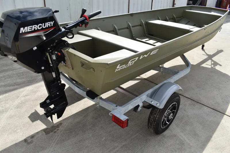 Slide: The Image of 2024 Lowe L1440M Jon boat with Mercury motor on trailer, parked outdoors. - 3