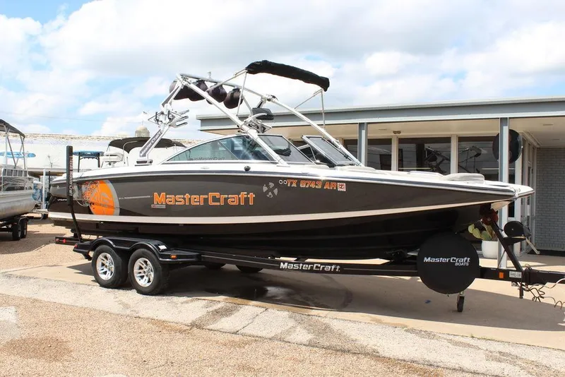 Slide: The Image of 2008 MasterCraft X45 boat on trailer, parked outdoors, featuring sleek design and vibrant graphics. - 1