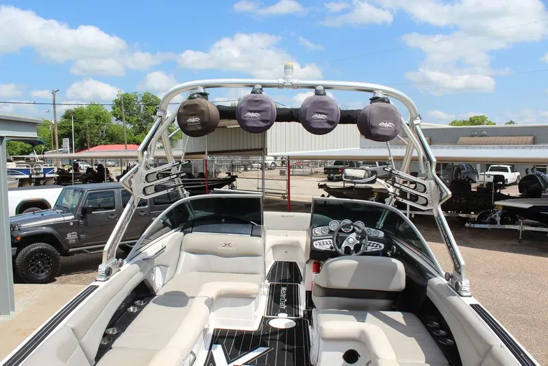 Slide: The Image of 2008 MasterCraft X45 boat interior with tower speakers and seating under a blue sky. - 13