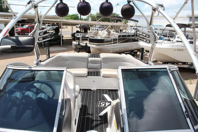 Slide: The Image of 2008 MasterCraft X45 boat interior with seating and wakeboard tower at a marina. - 18