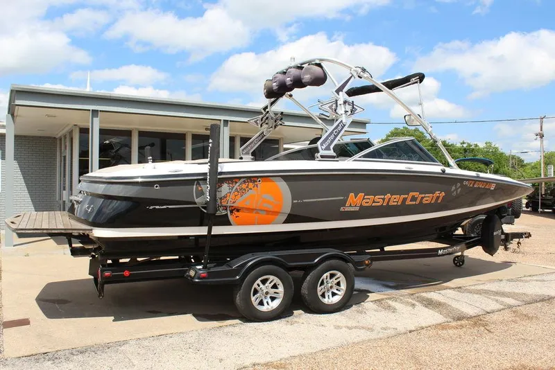 Slide: The Image of 2008 MasterCraft X45 boat on trailer, parked outdoors under a blue sky. - 2