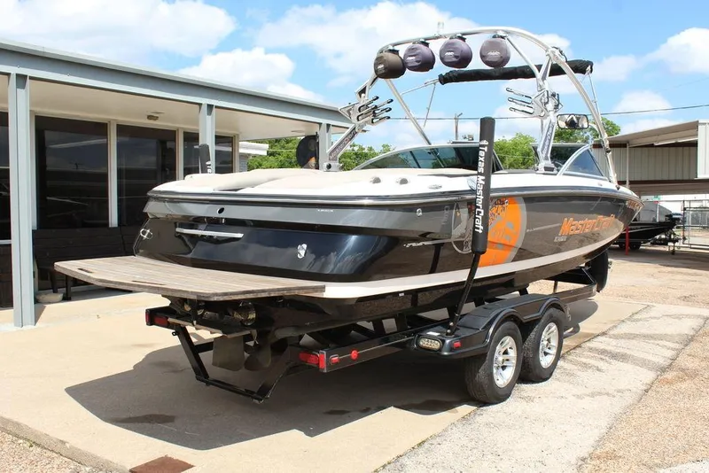 Slide: The Image of 2008 MasterCraft X45 boat on trailer, parked outside a building under a clear sky. - 4