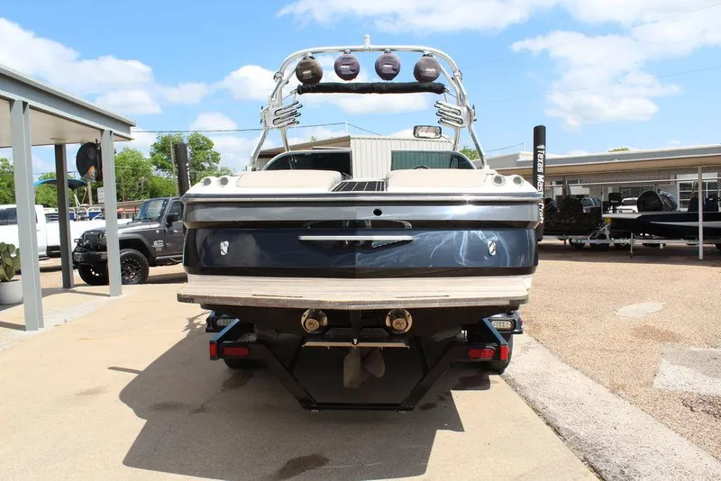 Slide: The Image of 2008 MasterCraft X45 boat, rear view, parked outdoors under a clear sky. - 5