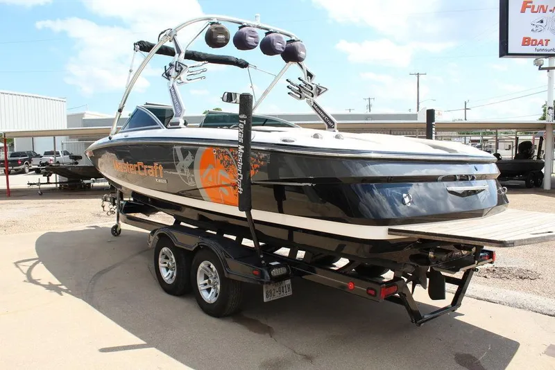 Slide: The Image of 2008 MasterCraft X45 boat on trailer, black and orange design, parked outdoors. - 6