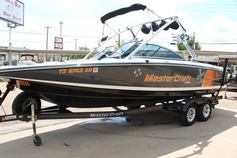 Slide: The Image of 2008 MasterCraft X45 boat on trailer, black and orange design, parked outdoors. - 8