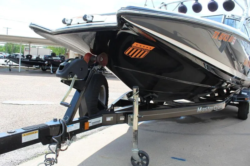 Slide: The Image of 2008 MasterCraft X45 boat on trailer, black hull, parked outdoors. - 9