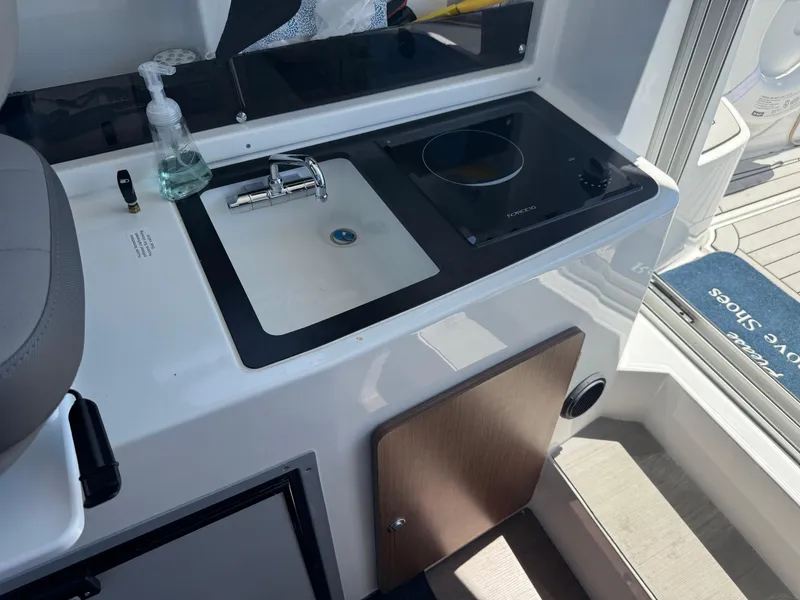 Slide: The Image of Compact kitchen area on 2021 Beneteau Antares 8 with sink and cooktop. - 19