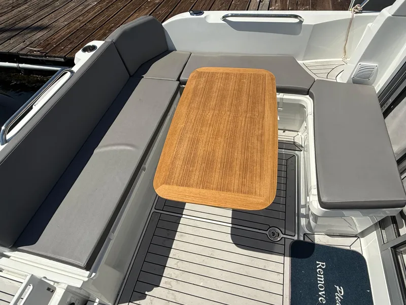 Slide: The Image of Interior of 2021 Beneteau Antares 8 with wooden table and gray seating. - 26