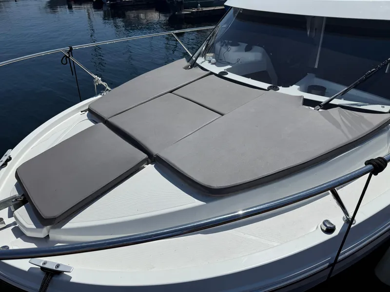 Slide: The Image of 2021 Beneteau Antares 8 boat with cushioned deck, docked on calm water. - 32