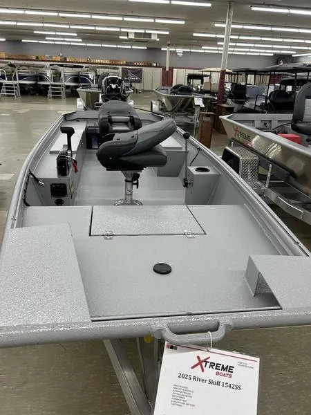 Slide: The Image of 2025 Xtreme River Skiff 1542SS boat displayed in showroom with seating and storage. - 3