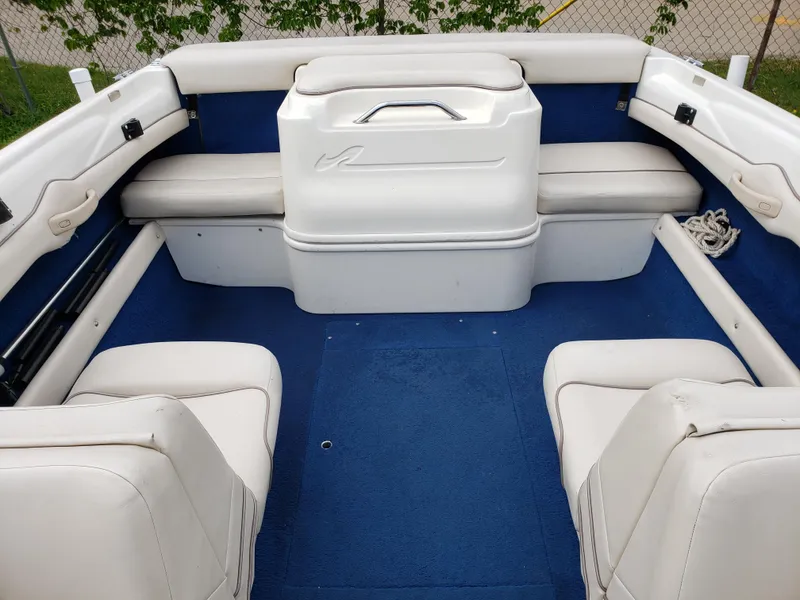 Slide: The Image of Interior of a 1995 Sea Ray 195BR boat with white seating and blue carpet. - 5