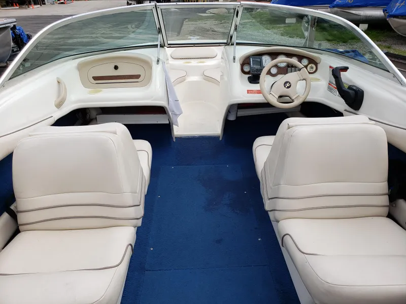 Slide: The Image of Interior of a 1995 Sea Ray 195BR boat with white seating and blue carpet. - 6