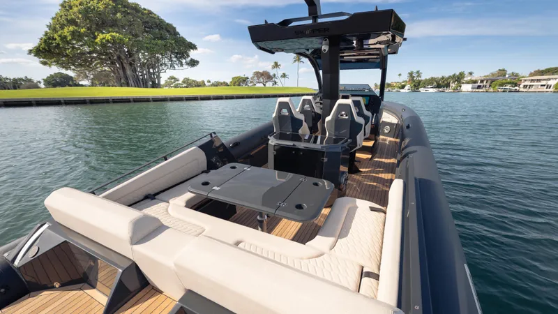 Slide: The Image of 2025 Skipper-BSK 38 boat with luxurious seating on a serene waterway. - 6