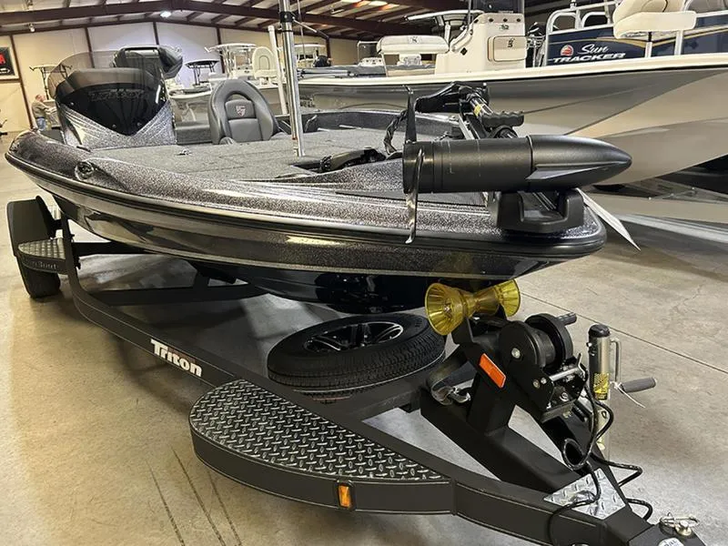 Slide: The Image of 2023 Triton 179 TrX bass boat on trailer in showroom setting. - 1