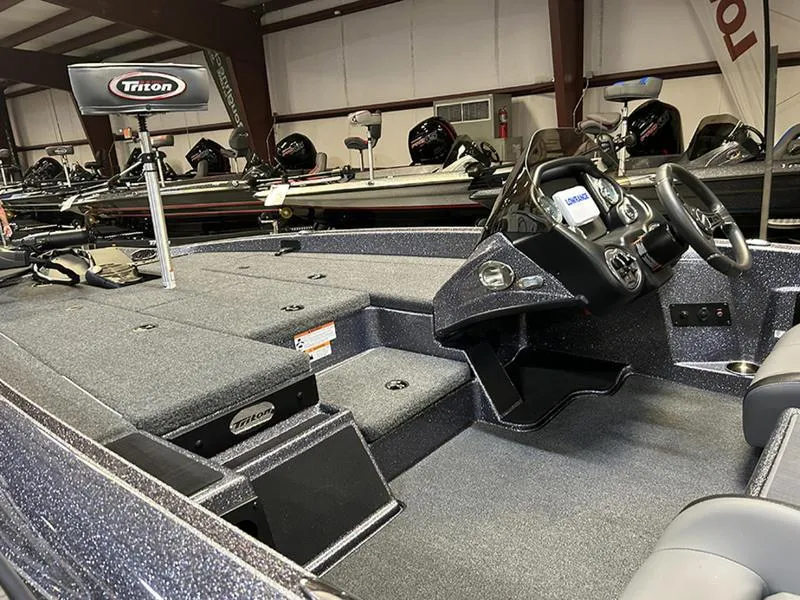 Slide: The Image of 2023 Triton 179 TrX boat interior with steering console and spacious deck. - 11