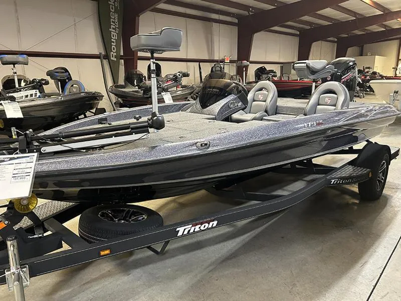Slide: The Image of 2023 Triton 179 TrX bass boat displayed indoors on a trailer. - 2