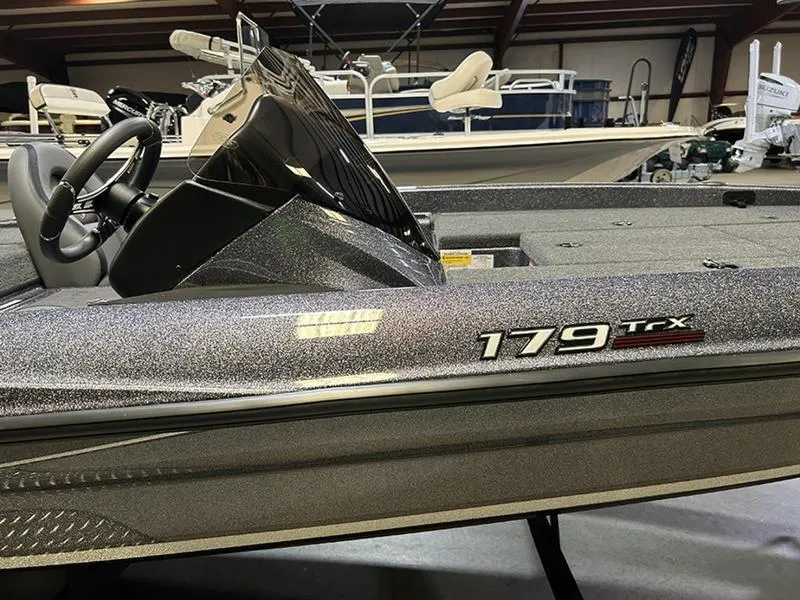 Slide: The Image of 2023 Triton 179 TrX boat in showroom, featuring sleek design and modern dashboard. - 5