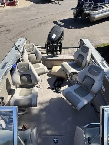 Slide: The Image of 2001 Lund 1700 Fisherman boat interior with seating and motor, docked outdoors. - 10