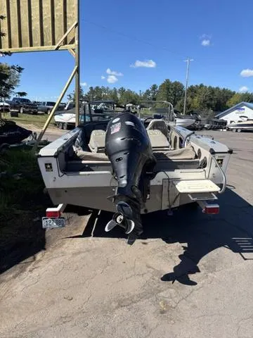 Slide: The Image of 2001 Lund 1700 Fisherman boat with outboard motor, parked outdoors on a sunny day. - 6