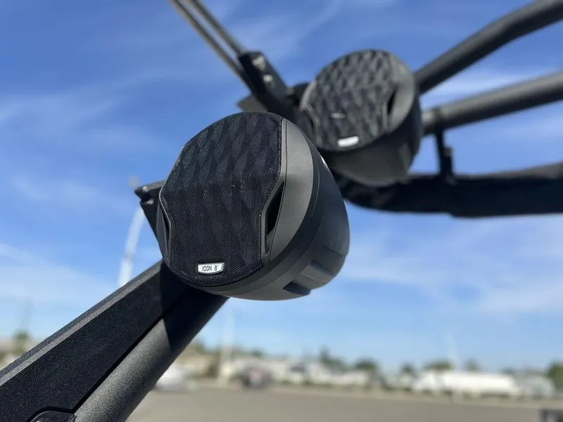 Slide: The Image of Close-up of speakers on a 2025 Malibu 25 LSV boat against a clear sky. - 11
