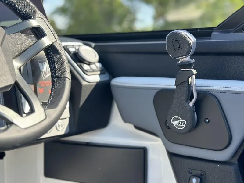 Slide: The Image of Interior view of 2025 Malibu 25 LSV boat, featuring steering wheel and control panel. - 13