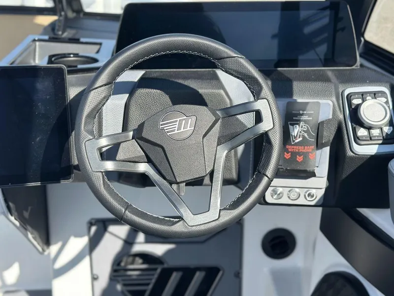 Slide: The Image of Steering wheel of a 2025 Malibu 25 LSV boat, featuring modern dashboard controls. - 14