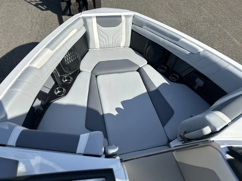 Slide: The Image of 2025 Malibu 25 LSV boat interior with luxurious seating and cup holders. - 22