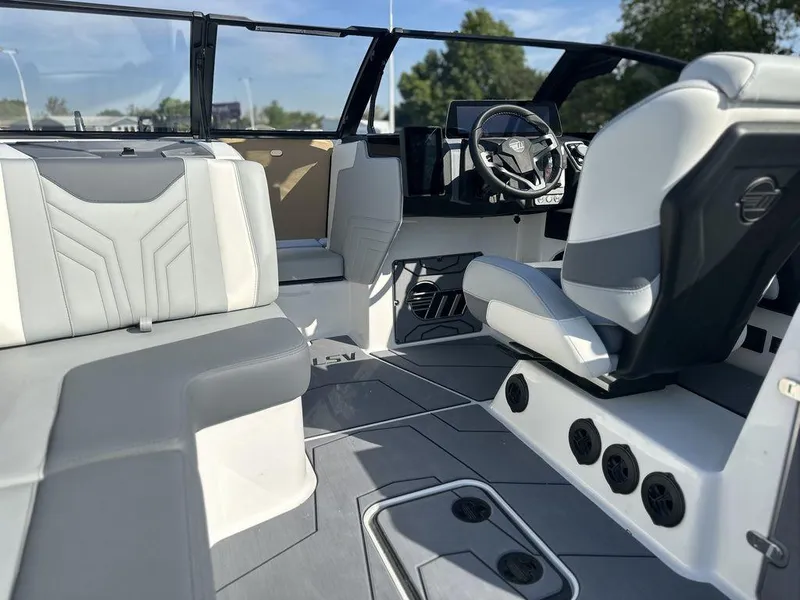 Slide: The Image of 2025 Malibu 25 LSV boat interior with modern seating and steering wheel. - 23