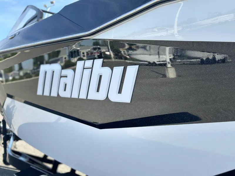 Slide: The Image of 2025 Malibu 25 LSV boat close-up, showcasing sleek design and logo. - 25