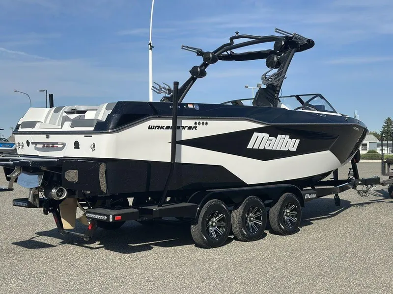 Slide: The Image of 2025 Malibu 25 LSV boat on trailer, black and white design, parked outdoors. - 28