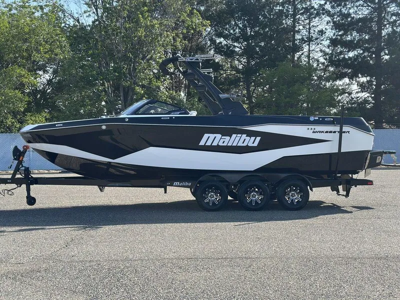 Slide: The Image of 2025 Malibu 25 LSV boat on trailer, parked outdoors, side view. - 31