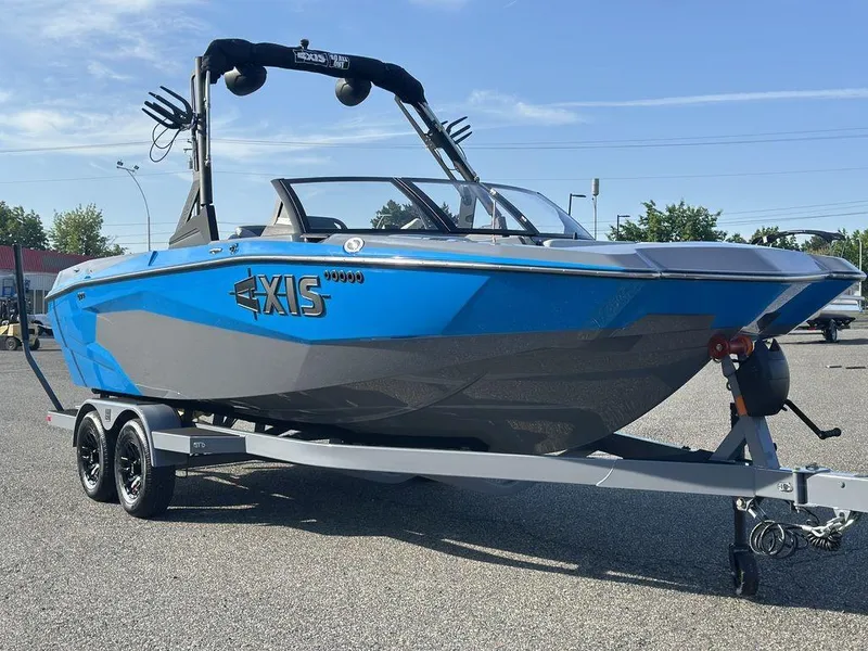 The Image of 2025 Axis A225 boat in blue and gray on a trailer, parked outdoors. - 0