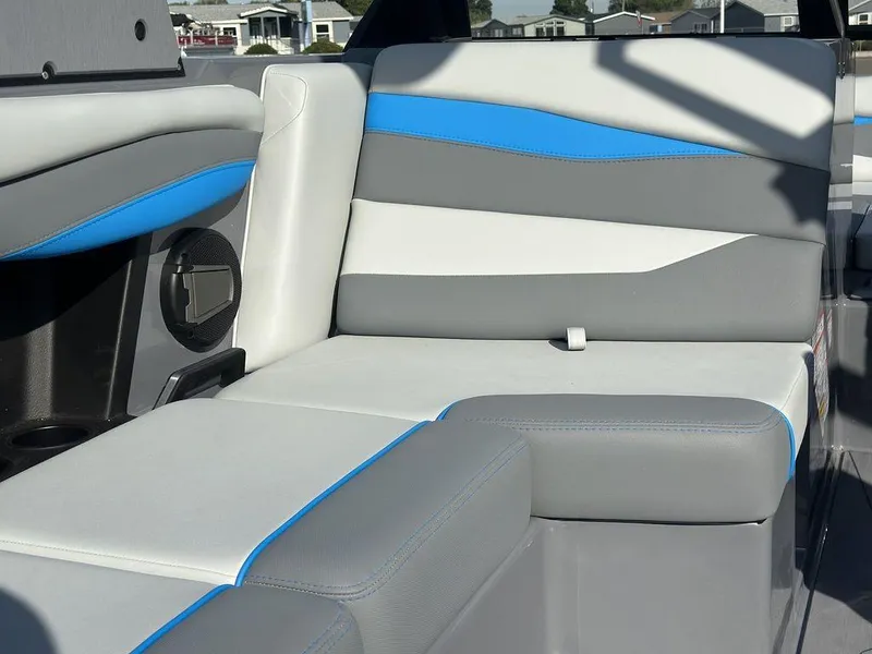 Slide: The Image of 2025 Axis A225 boat interior with gray, white, and blue cushioned seating. - 13