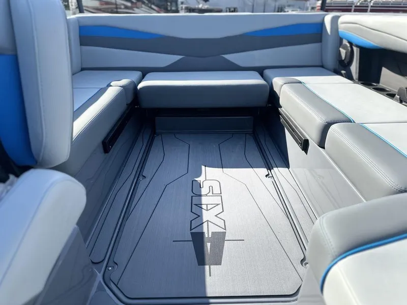 Slide: The Image of 2025 Axis A225 boat interior with gray and blue seating, featuring "Axis" branding on the floor. - 8
