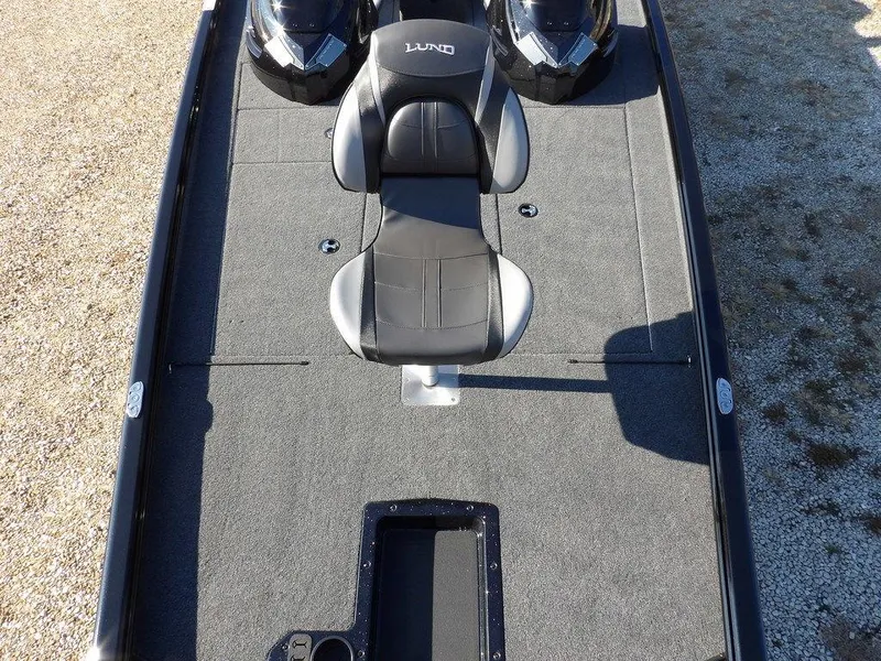 Slide: The Image of 2025 Lund 1975 Renegade SS boat interior with black seating and carpeted deck. - 13