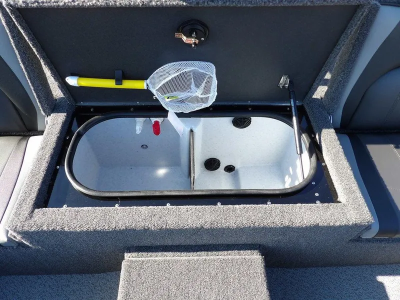 Slide: The Image of Livewell compartment in a 2025 Lund 1975 Renegade SS boat, featuring fishing net and aeration system. - 36