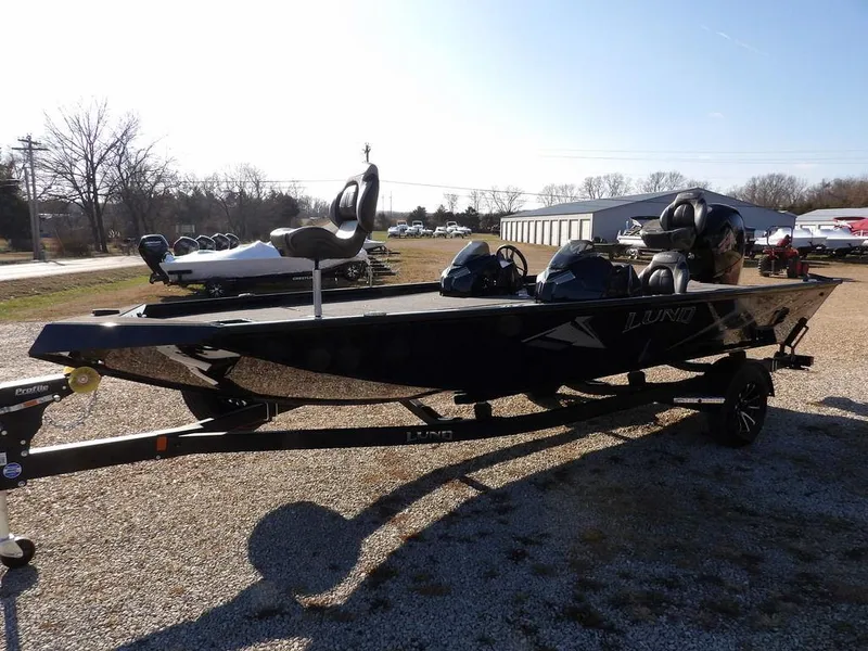 Slide: The Image of 2025 Lund 1975 Renegade SS boat on trailer, parked outdoors on gravel. - 46